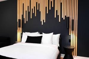 a bedroom with a white bed and a wall with goldipes at #6 - Artistic Studio - Self Check in - Plateau - St-Denis - AC - TV in Montréal