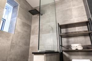 a bathroom with a shower with a glass door at #6 - Artistic Studio - Self Check in - Plateau - St-Denis - AC - TV in Montréal +14 photos