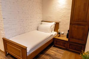 a bed in a room with a white brick wall at Bujtina Jaki in Gjakove