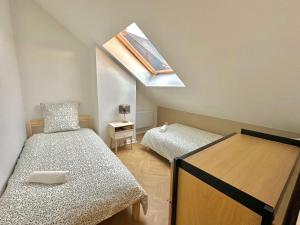 a small bedroom with a bed and a skylight at Maison Familiale Le Havre in Le Havre