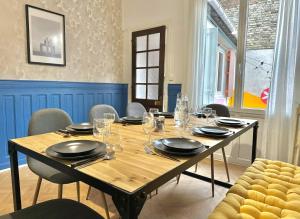 a dining room table with glasses and plates on it at Maison Familiale Le Havre in Le Havre +18 photos