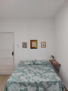 a bedroom with a bed with a green comforter at Projeto FZ Hospedagem in Salvador