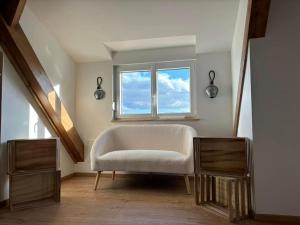a living room with a chair and a window at La Perle d'Alsace in Bernardswiller