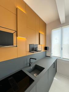 a kitchen with a sink and a tv on the wall at Modflor Urban Flat Florence in Florence