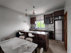 une cuisine avec une table et quelques chaises dans l'établissement Vista Luxury Apartment, à Kigali