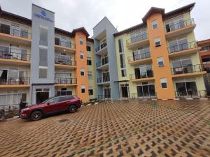 une voiture rouge garée devant un bâtiment dans l'établissement Vista Luxury Apartment, à Kigali