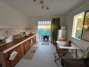 a kitchen with a sink and a table with a tablektop at Les Âmes-Claires 2 in Terre-de-Haut