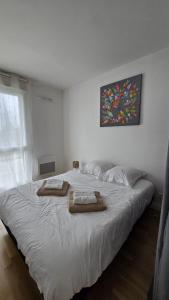 a bedroom with a bed with two towels on it at Vacances Ô Kastel - Studio Centre Ville proche de la mer in Fouesnant
