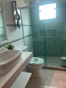 une salle de bain avec toilettes et douche en verre dans l'établissement casa da maria, à Cabo Frio