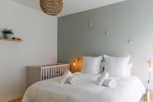 a bedroom with a white bed with white pillows at La Perle in Plobannalec-Lesconil
