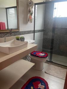 une salle de bain avec un lavabo, des toilettes et une douche dans l'établissement casa da maria, à Cabo Frio
