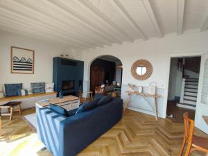 a living room with a blue couch and a table at La Perle in Plobannalec-Lesconil