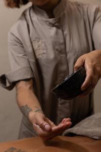 a person holding a remote control in their hands at Il Grottino Relais & Spa in Gualdo Cattaneo