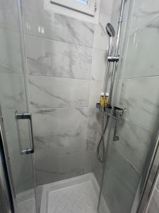 Un baño con ducha con puerta de cristal en APPARTEMENT AU CŒUR DE MARAIS DANS CENTRE de PARIS, en París