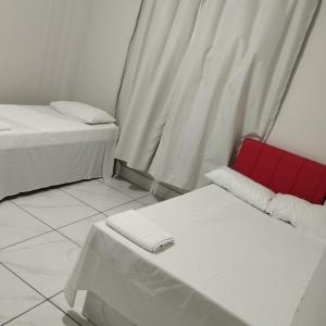 a room with two beds and a red chair at Hotel Rodoviária Belo Horizonte in Belo Horizonte +22 photos
