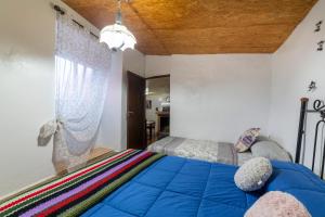 a bedroom with a blue bed and a window at Casa rural Mccoy in Macael