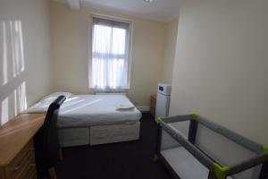 a small bedroom with a bed and a window at York Hotel in Ilford