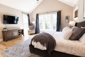 a bedroom with a large bed and a tv at Minutes to Downtown Huge Outdoor Deck HOT TUB in Nashville +50 photos