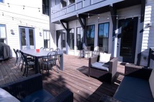 a wooden deck with a table and chairs on a house at Minutes to Downtown Huge Outdoor Deck HOT TUB in Nashville