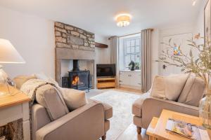 a living room with two couches and a fireplace at Weavers Cottage Newly converted luxurious retreat in Kirkby Lonsdale
