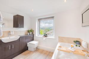a bathroom with a sink and a toilet and a window at Weavers Cottage Newly converted luxurious retreat in Kirkby Lonsdale +56 photos
