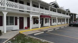 a parking lot in front of a white building at The Chalet Motel in Mequon
