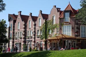ein großes Backsteingebäude mit Leuten davor in der Unterkunft Hotel Altes Zollhaus in Horumersiel