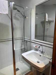 baño blanco con ducha y lavamanos en La Casona de Pío, en Cudillero 37 fotos más