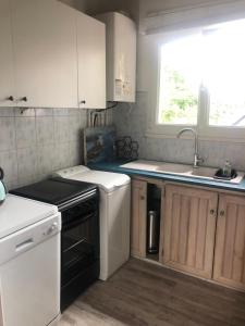 a kitchen with white cabinets and a sink and a dishwasher at Lau Anaiak in Bidart