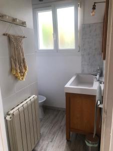 a bathroom with a radiator and a sink and a window at Lau Anaiak in Bidart +6 photos