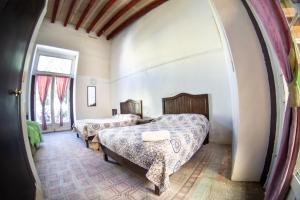 a bedroom with two beds and a window at La Fuente Catedral in Puebla