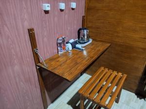 a wooden table with a coffee maker and two chairs at Indah Damai Cottages in Sidomukti
