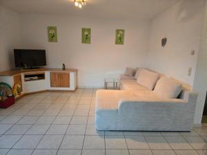 a living room with a couch and a tv at Ferienhaus Vongerichten in Oberhausen