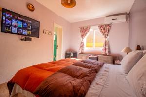 a bedroom with a large bed with an orange blanket at Nona Amabile in São Lourenço do Sul