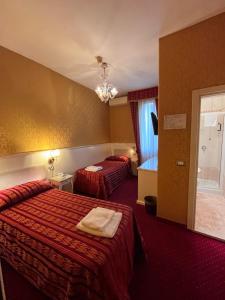 a hotel room with two beds and a window at Hotel Castello in Venice
