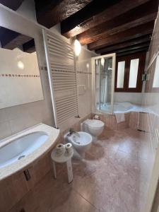 a bathroom with a tub and a toilet and a sink at Hotel Castello in Venice