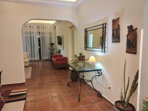 een woonkamer met een rode bank en een tafel bij Cobertura com churrasqueira São Vicente in São Vicente