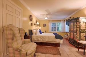 a bedroom with a bed and a chair at The Caribbean Court Boutique Hotel in Vero Beach