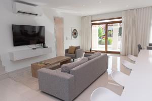 a living room with two couches and a flat screen tv at Opal Rental II in Palm-Eagle Beach