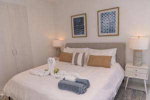 a bedroom with a white bed with towels on it at Opal Rental II in Palm-Eagle Beach +27 photos