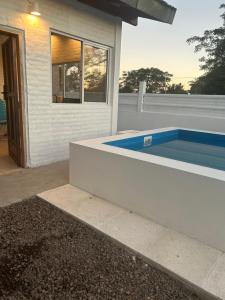 a swimming pool in the backyard of a house at Remanso casa fuera del tiempo in Riachuelo