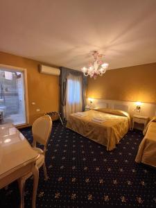 a hotel room with two beds and a chandelier at Hotel Castello in Venice