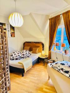 a bedroom with two beds and a large window at Historical house with view and separate entrance in Ålesund