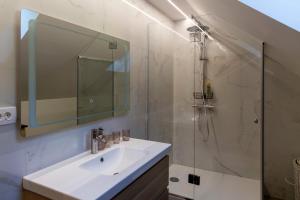 ein Badezimmer mit Waschbecken und Dusche mit Spiegel in der Unterkunft Peaceful Slovenj Gradec Holiday Villa Escape in Pameče + 35 Fotos