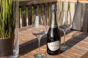 eine Flasche Wein und zwei Weingläser auf einem Tisch in der Unterkunft Peaceful Slovenj Gradec Holiday Villa Escape in Pameče