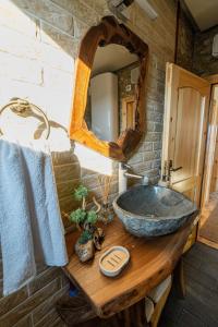 a bathroom with a stone sink and a mirror at Къщи за гости 'Веринско' in Verinsko