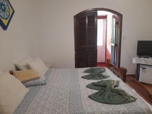 um quarto com uma cama com duas toalhas verdes em Pousada Maria de Lino em São Sebastião