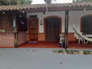 uma casa com uma rede na frente em Pousada Maria de Lino em São Sebastião