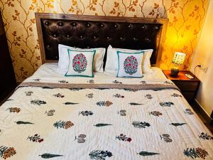 a bedroom with a bed with a quilt and pillows at Rosa Heritage Abode - 3BHK Spacious Home in Jaipur
