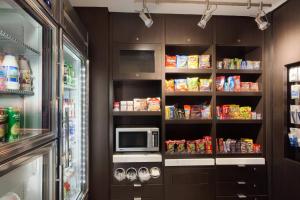 a kitchen with a refrigerator and a microwave at Courtyard by Marriott Oklahoma City North/Quail Springs in The Village